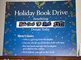 A Holiday Book Drive sign encourages donations to KNTR.