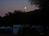 The moon rises as the festival continues with night activities.
