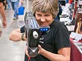 Denise plays with a <em>Star Wars</em> prop that was raffled for KNTR over the weekend for by Anarchy Squared Creations. © Carl Wagner