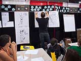 Steven adds another character illustration to the storyboard, which is lined with reading pledges at the top. © Carl Wagner
