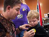 Last year's KNTR Geek Prom Prince stops by for a visit and receives a KNTR button. © Robert Gary