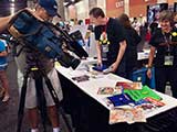 Fox 10 Phoenix gets a close-up of KNTR's goodie backpack, sponsored by Bookmans. © Robert Gary