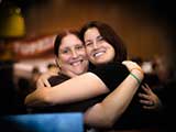 Volunteers Whitney and Rachel share the joy! (We are a huggy bunch!) © Robert Gary