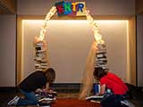 KNTR volunteers assemble the Geek Arch photo backdrop. © Bruce Matsunaga