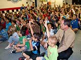 The principal of CFA Phoenix, Jarret Sharp, sat on the floor with his students during the program. © Denise Gary