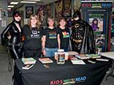 Catwoman and Batman took a moment to join Debb, Denise, and Nacole at the KNTR table. © Denise Gary