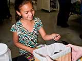 A little girl smiles at her KNTR button. © Denise Gary